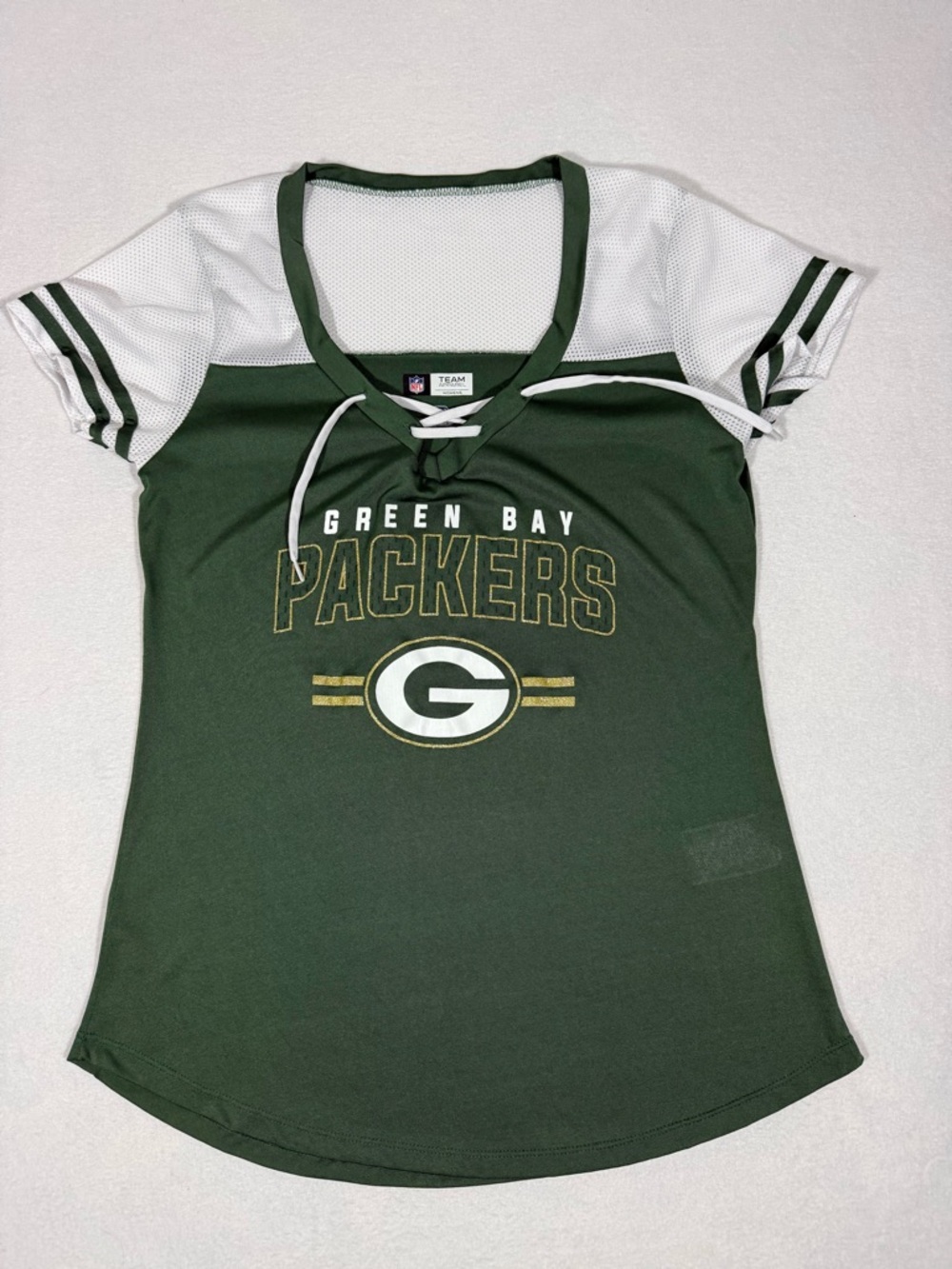 NFL women's Green Bay Packers short sleeve lace up T with mesh sleeve detail.